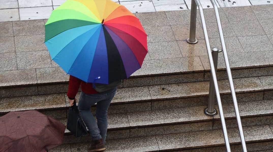 Άνδρας με ομπρέλα βγαίνει από σταθμό Μετρό