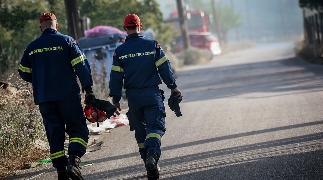 Πυροσβέστες περπατούν σε δρόμο