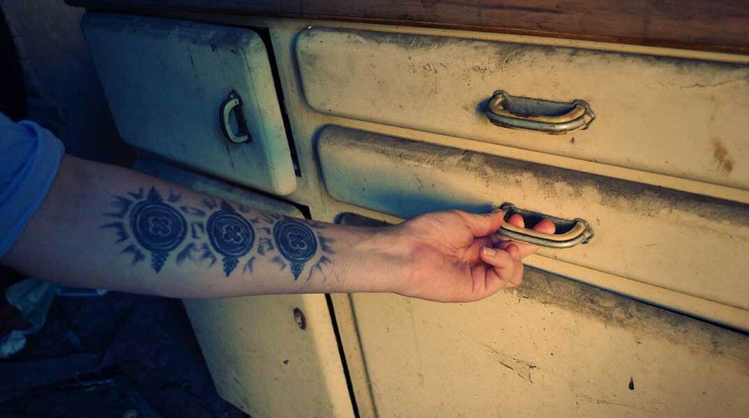 Χέρι ανοίγει συρτάρι σε παλιό έπιπλο