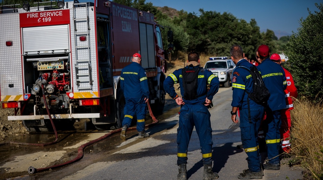 Πυροσβέστες δίπλα από όχημα