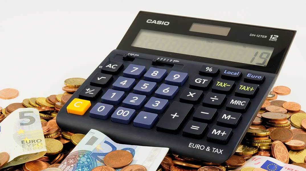 Κέρματα και χαρτονομίσματα του ευρώ μαζί με κομπιουτεράκι