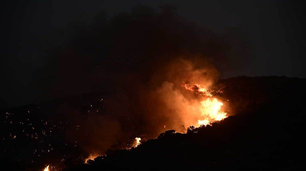 Φωτιά καίει περιοχή με χαμηλή βλάστηση και δέντρα κατά τη διάρκεια της νύχτας