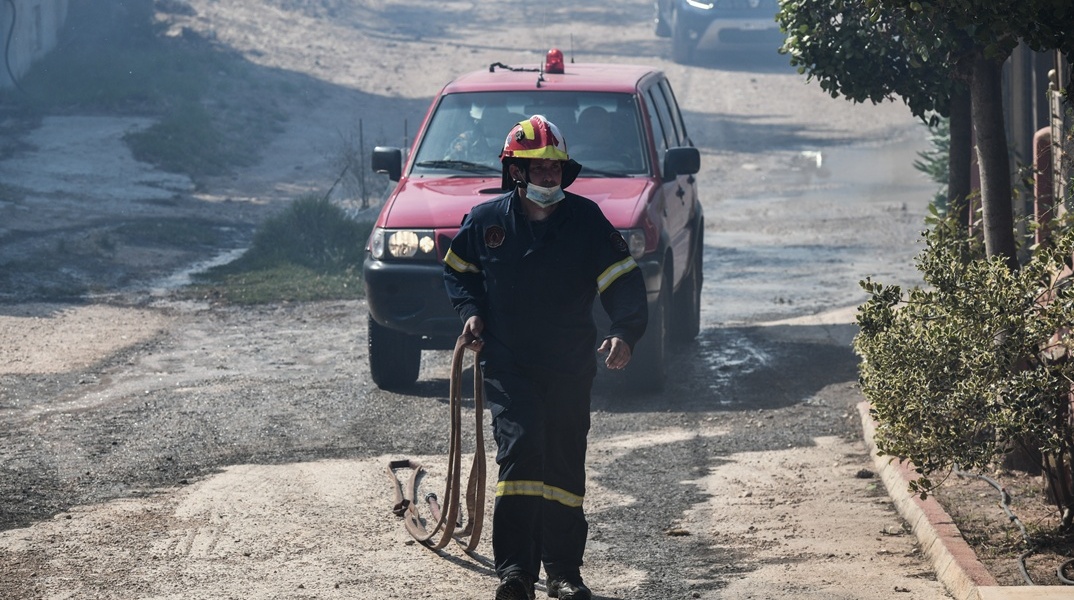 Πυροσβέστης μπροστά από όχημα της Πυροσβεστικής