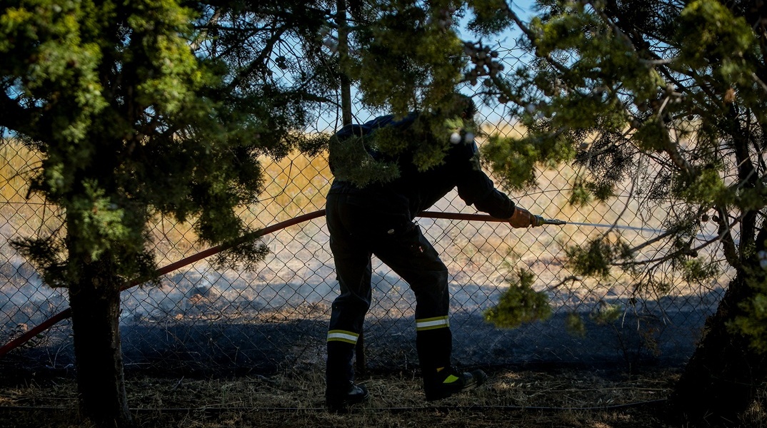 Πυροσβέστης με μάνικα ανά χείρας