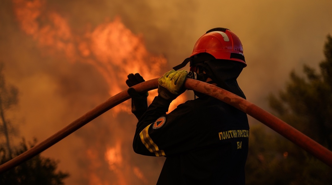 Πυροσβέστης με τη μάνικα ανά χείρας στη φωτιά στη Δυτική Αττική