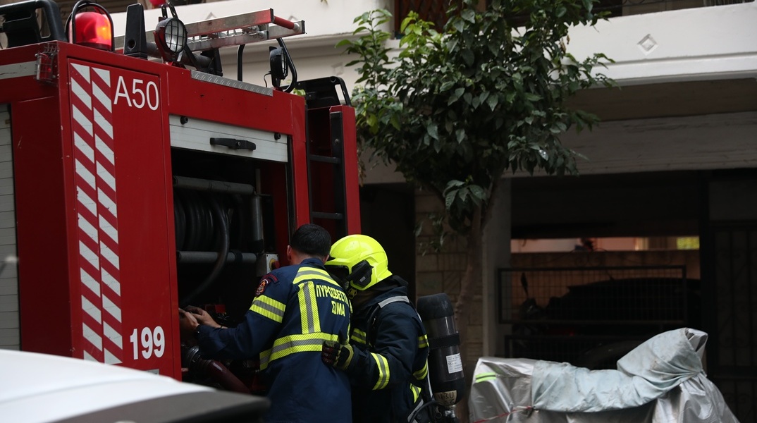 Πυροσβέστες πίσω από όχημα του Σώματος