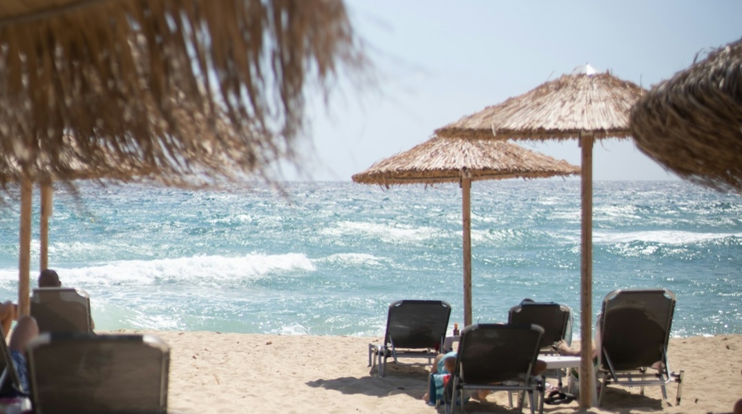 Παραλία με ξαπλώστρες και ομπρέλες