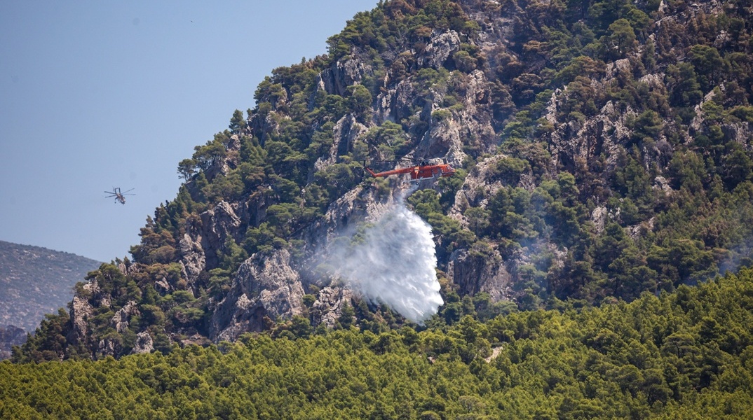 Πυροσβεστικό ελικόπτερο πάνω από δασική έκταση που έχει πάρει φωτιά