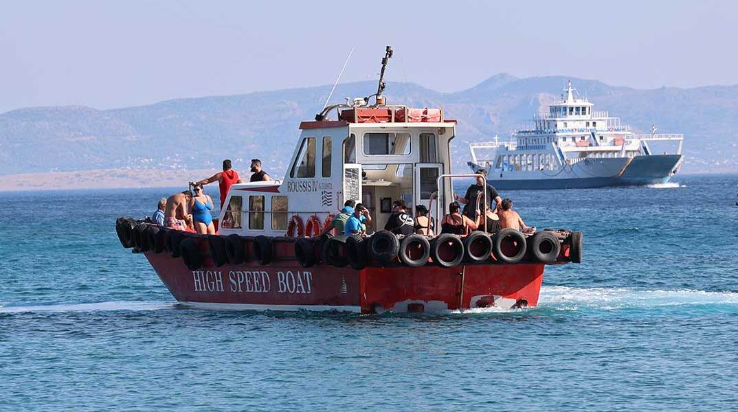 Κάτοικοι και επισκέπτες απομακρύνονται με σκάφη από παραλίες στη Σαλαμίνα