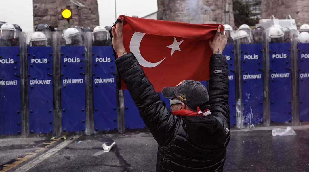 Διαδηλωτής με την τουρκική σημαία μπροστά σε αστυνομικούς