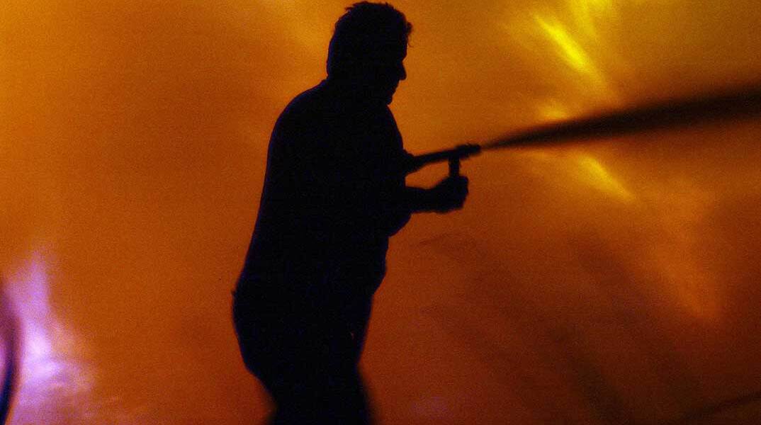 Πυροσβέστης σβήνει φωτιά