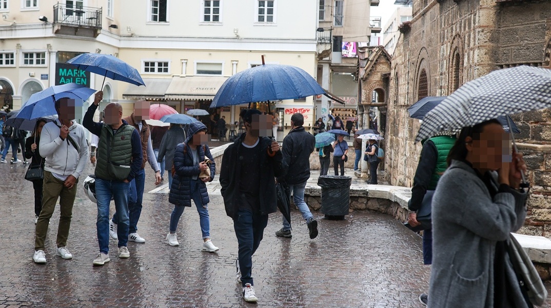Πολίτες με ομπρέλες στην Ερμού