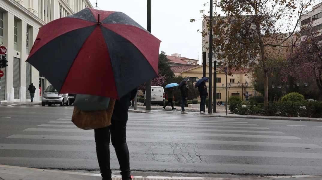 Γυναίκα με ομπρέλα στον δρόμο