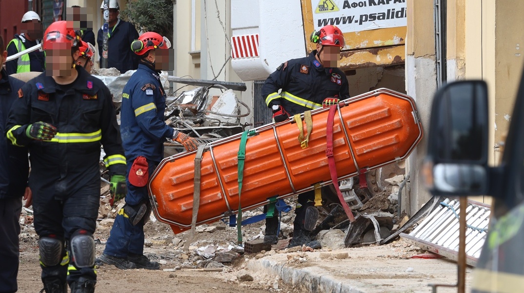 Διασώστες μεταφέρουν φορείο στα συντρίμμια για τη μεταφορά της σορού που εντοπίστηκε στην Πλάκα