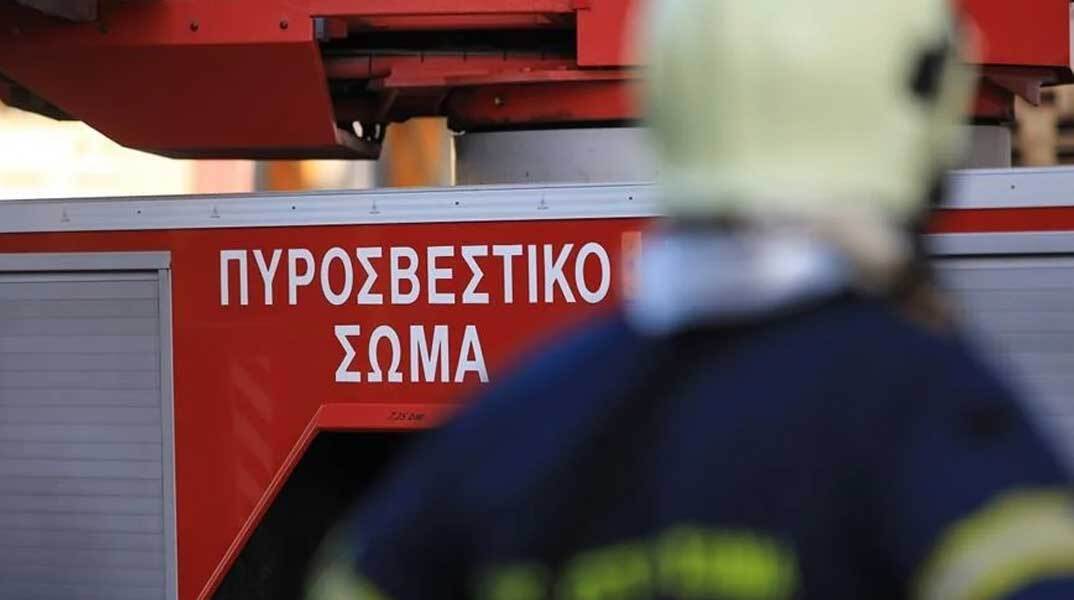 Πυροσβέστης μπροστά από πυροσβεστικό όχημα