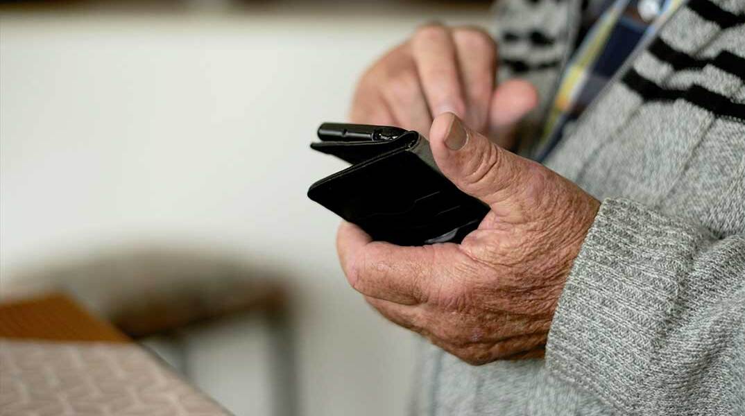 Συνταξιούχος με το κινητό τηλέφωνο στο χέρι