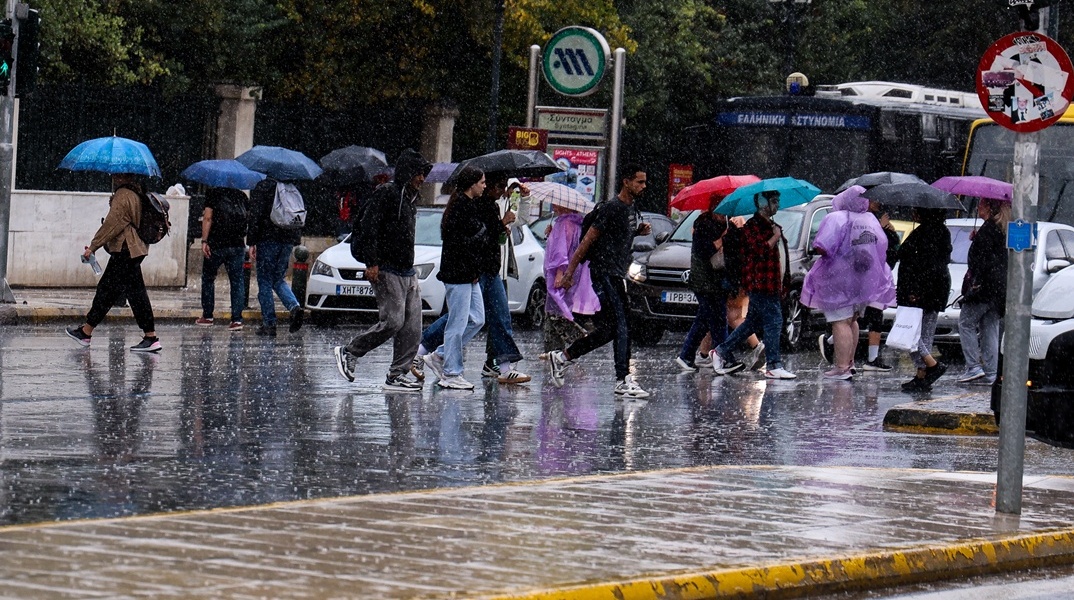Πολίτες με ομπρέλες εν μέσω βροχής στο Σύνταγμα