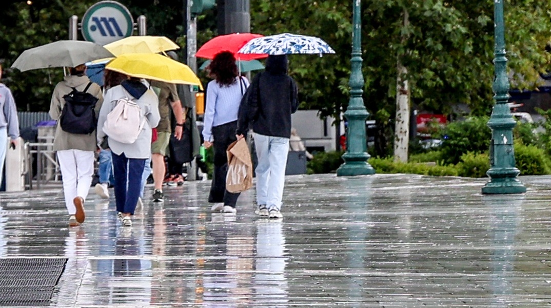 Πολίτες με ομπρέλες εν μέσω βροχής στο κέντρο της Αθήνας