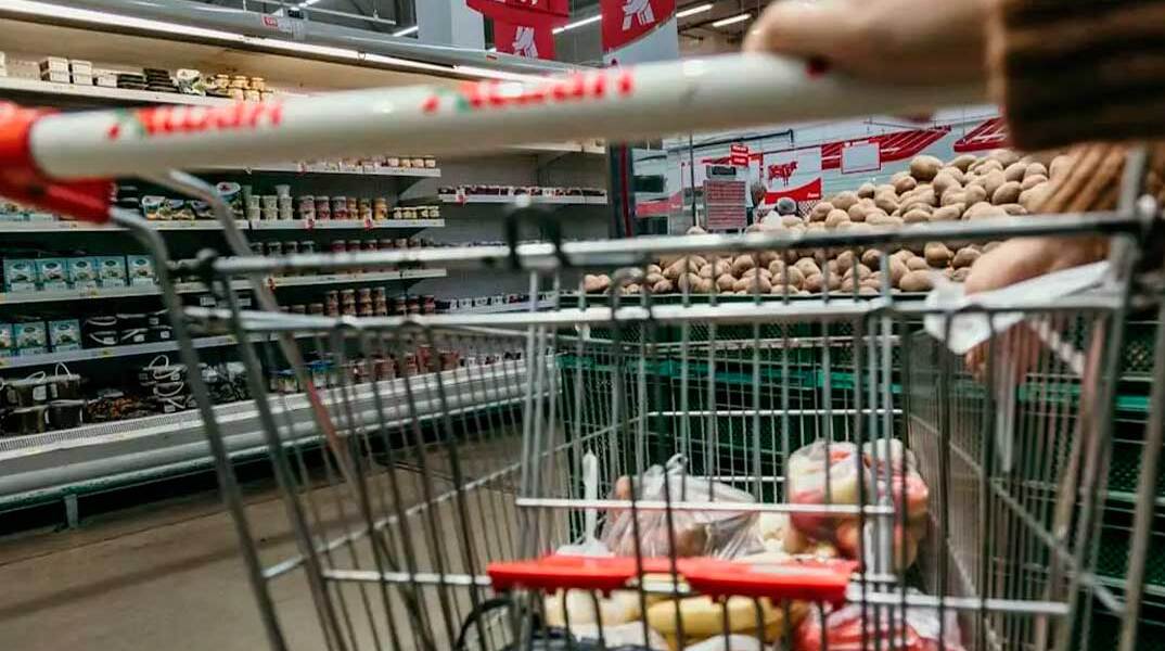 Καρότσι με τρόφιμα σε διάδρομο σούπερ μάρκετ