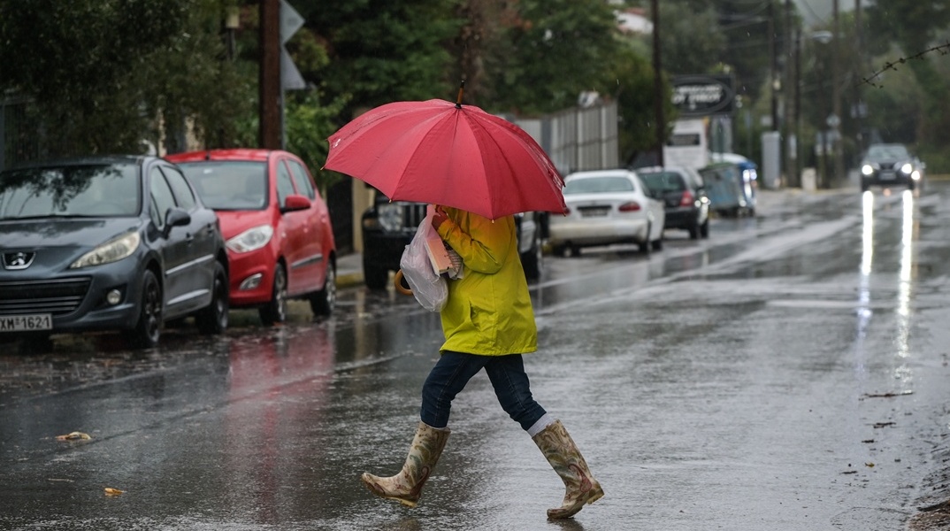 Γυναίκα υπό βροχή με ομπρέλα