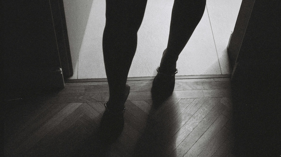 Πόδια γυναίκας που φορά τακούνια στο ημίφως