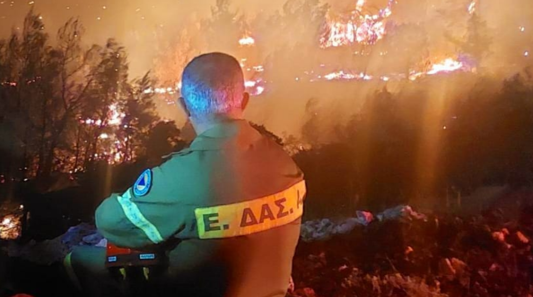 Ο εθελοντής πυροσβέστης κοιτάζει αποκαρδιωμένος τη φωτιά
