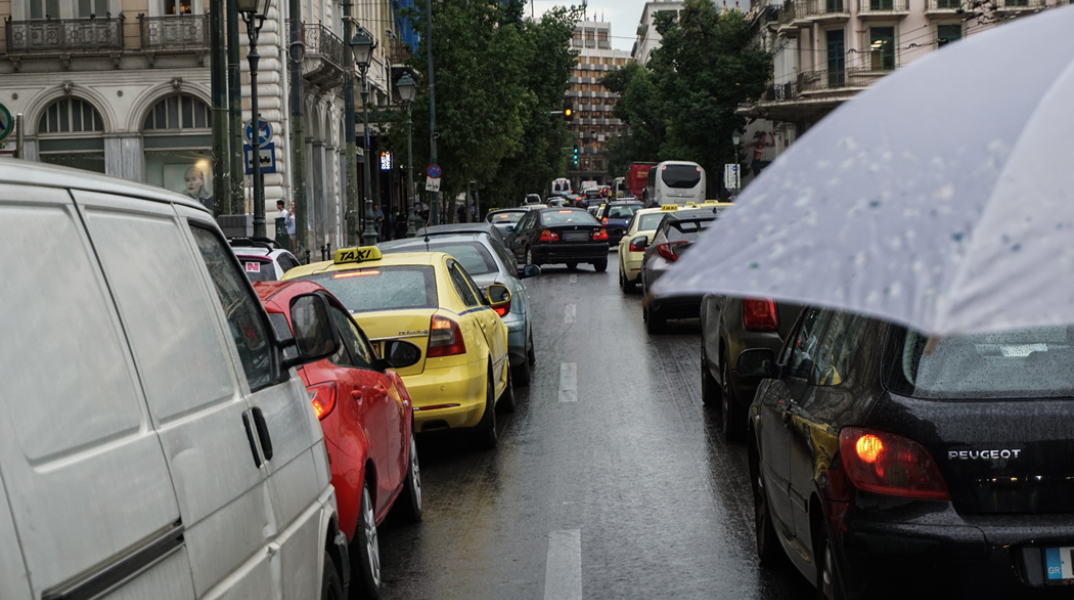 Αυτοκίνητα κολλημένα στην κίνηση ενώ βρέχει