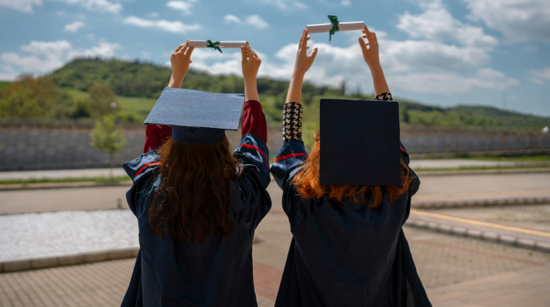 Νεαρές γυναίκες με τίβενο κρατούν στα χέρια τους το πτυχίο τους 