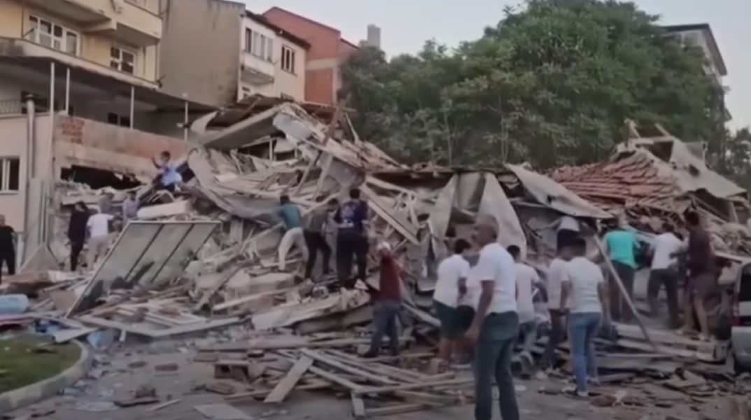 Πολίτες πάνω από τα συντρίμμια κτιρίου στην Τουρκία