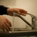 Άτομο γεμίζει ποτήρι με νερό βρύσης