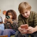 Παιδιά μπροστά από οθόνες κινητών και τάμπλετ