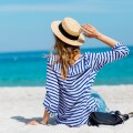 Γυναίκα με ψάθινο καπέλο στην παραλία