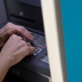 Άτομο μπροστά σε ΑΤΜ πληκτρολογεί τον κωδικό της κάρτας του