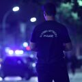 Αστυνομικός μπροστά από περιπολικό