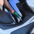 Εργαζόμενος σε πρατήριο υγρών καυσίμων βάζει βενζίνη σε μηχανάκι