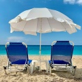 Παραλία στη Λευκάδα με δύο ξαπλώστρες και μία ομπρέλα καρφωμένη στην άμμο