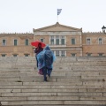 Πολίτες με ομπρέλα και αδιάβροχο μπροστά στη Βουλή