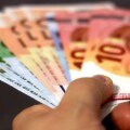 Χέρι κρατά χαρτονομίσματα ευρώ