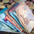 Διπλωμένα χαρτονομίσματα και κέρματα του ευρώ