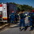 Πυροσβέστες δίπλα από όχημα