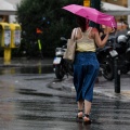 Γυναίκα με ομπρέλα εν μέσω καλοκαιρινού μπουρινιού