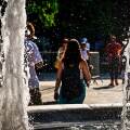 Κόσμος περνά μπροστά από το συντριβάνι στην πλατεία Συντάγματος