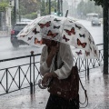 Γυναίκα κρατά ομπρέλα εν μέσω ισχυρής καταιγίδας