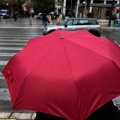 Πολίτες με ομπρέλα προστατεύονται από τη βροχή στο κέντρο της Αθήνας