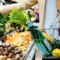 Γυναίκα βάζει στο καλάθι του σούπερ μάρκετ προϊόντα