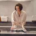 Νοικοκυρά τυλίγει με αλουμινόχαρτο τρόφιμα στην κουζίνα