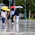 Πολίτες με ομπρέλες εν μέσω βροχής στο κέντρο της Αθήνας
