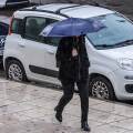 Γυναίκα με ομπρέλα εν μέσω κακοκαιρίας στην Αττική