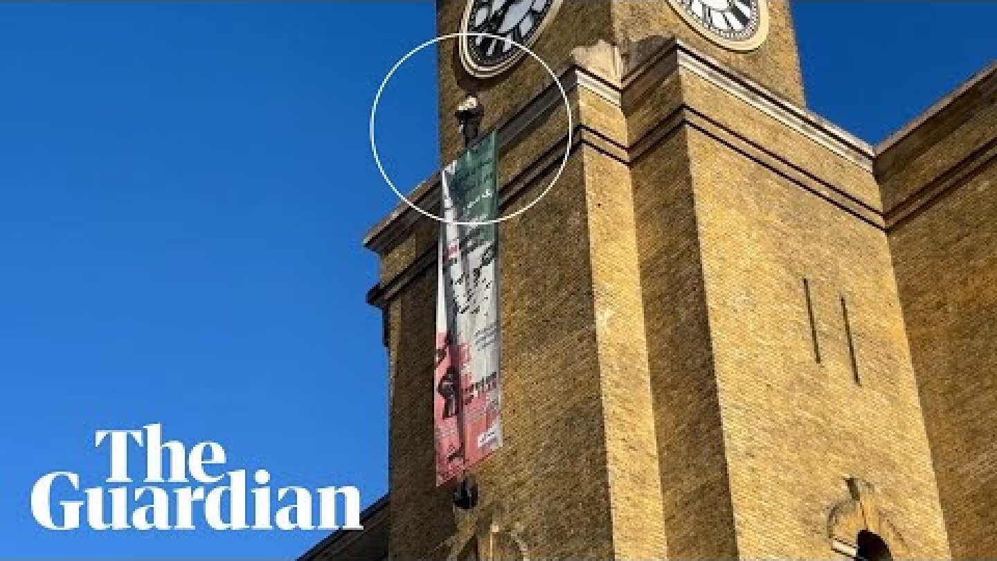 'Freedom for Iran' protester on top of King's Cross station holding dog