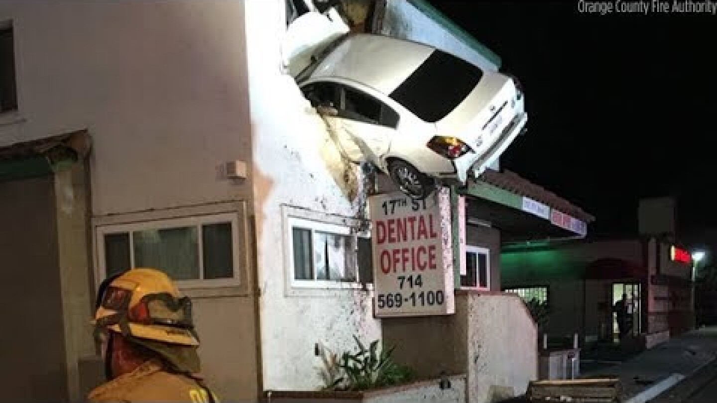 Car goes airborne, slams into second floor of building